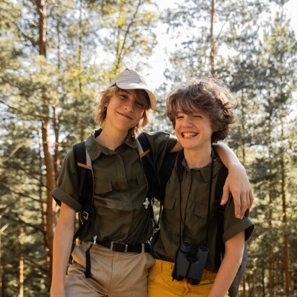 twee jongens in scoutsuniform in bos